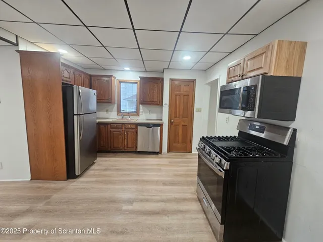 a kitchen with stainless steel appliances granite countertop a refrigerator and a stove
