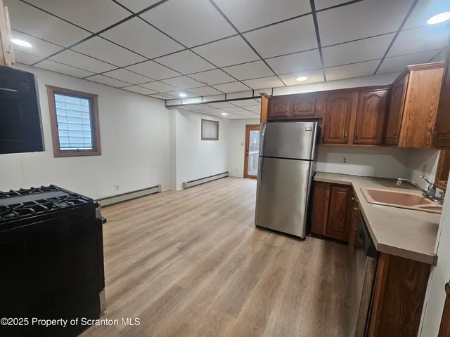a kitchen with a refrigerator and a stove top oven