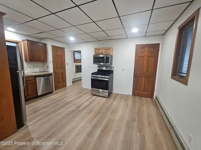 a view of a kitchen with a sink refrigerator and wooden floor