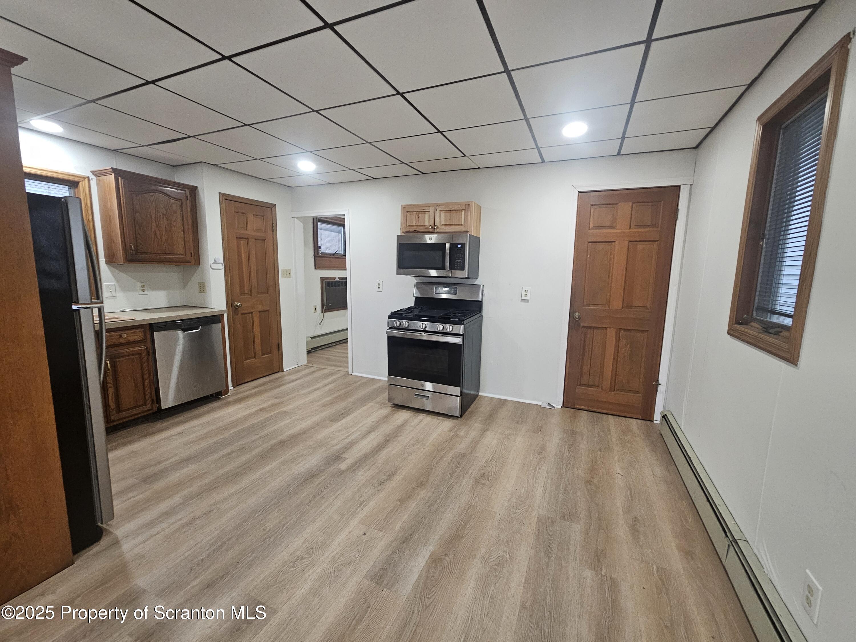 328 4th Street Blakely, PA 18447 - Photo 5 of 13 a view of a kitchen with a sink refrigerator and wooden floor