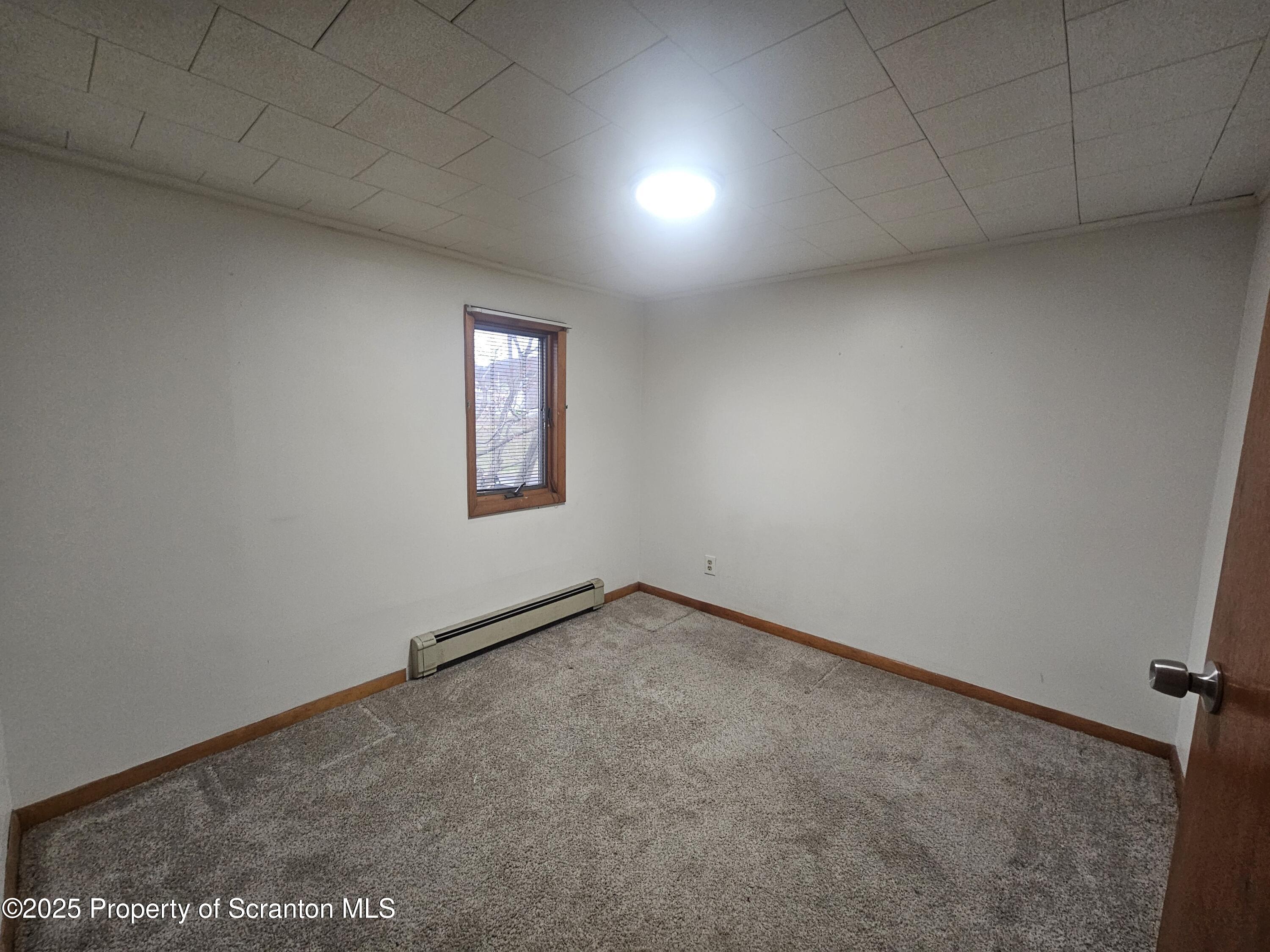 328 4th Street Blakely, PA 18447 - Photo 8 of 13 an empty room with a empty space and windows
