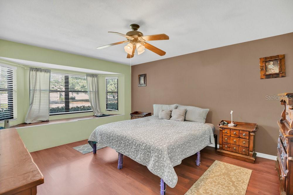 90 Sundown Road DeBary, FL 32713 - Photo 16 of 36 a bedroom with a large bed and a chandelier