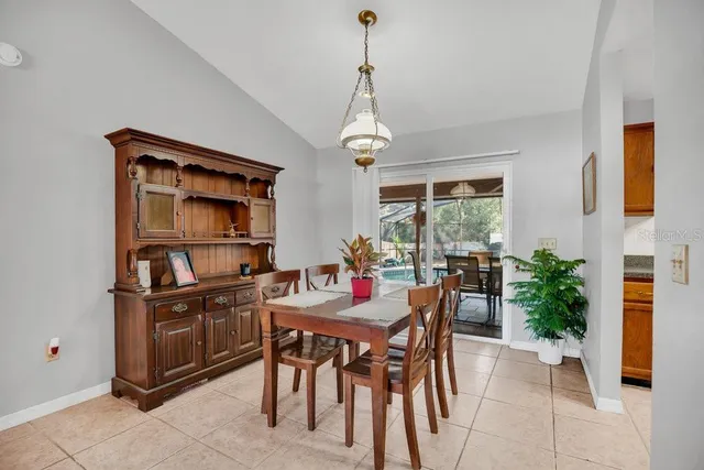 a dining room with furniture a chandelier and window