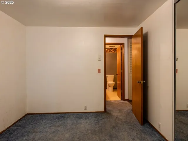 a view of a hallway with wooden floor and stairs