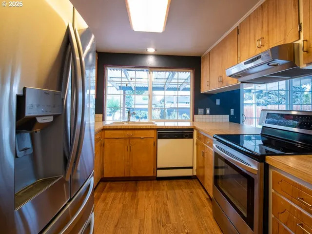 a kitchen with a sink and steel appliances