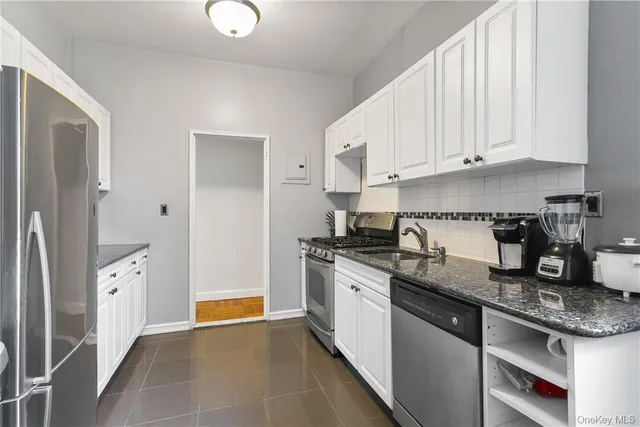 a kitchen with stainless steel appliances granite countertop a stove a sink and a refrigerator
