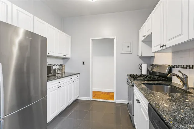 a kitchen with granite countertop a sink stove and refrigerator