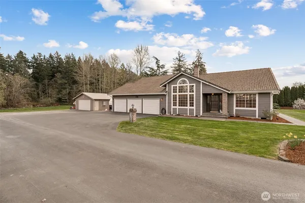 a view of a house next to a yard with big trees
