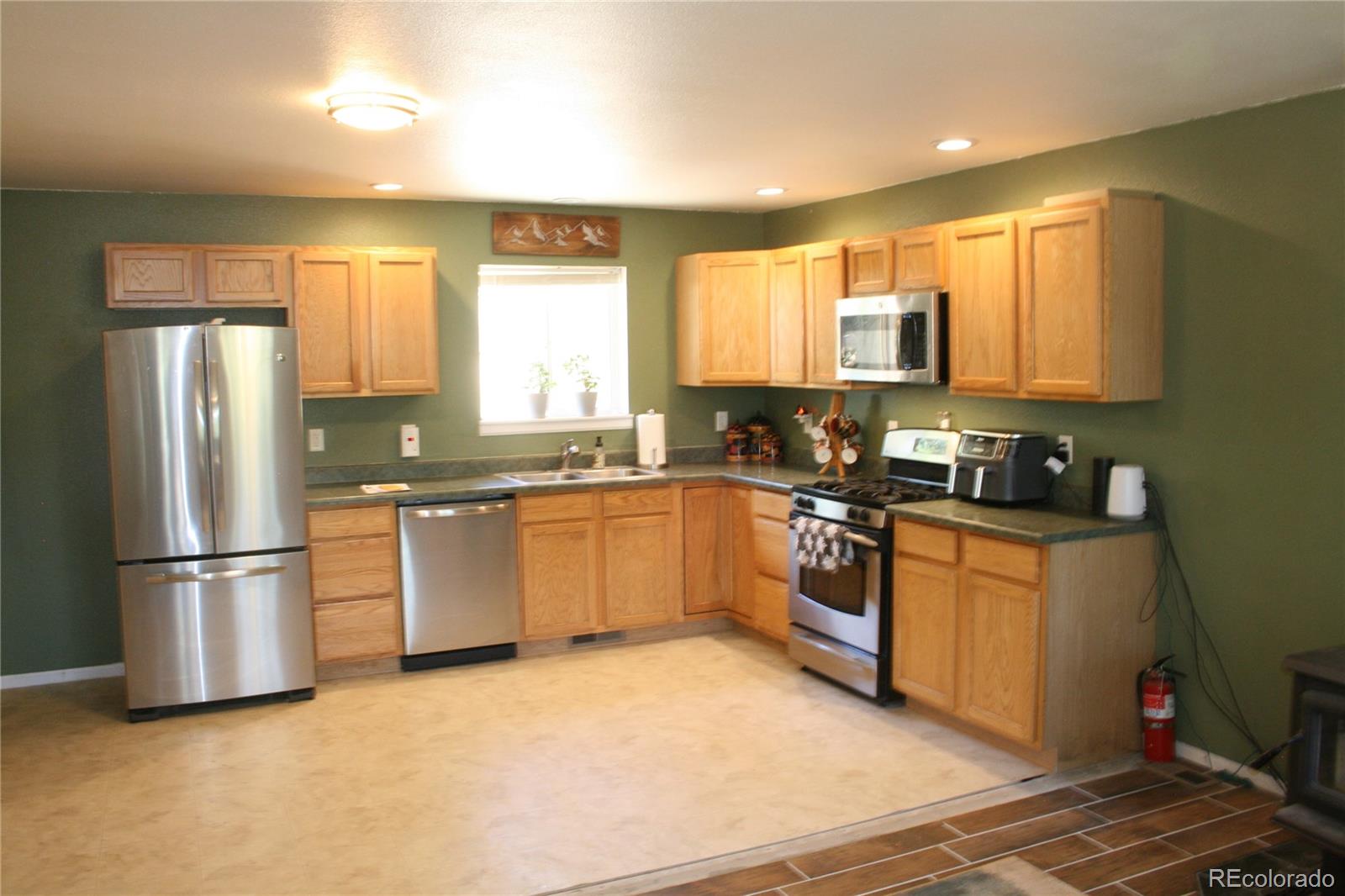 238 Taylor Street Bailey, CO 80421 - Photo 12 of 23 a kitchen with stainless steel appliances granite countertop a refrigerator a sink a stove a microwave a counter space and cabinets