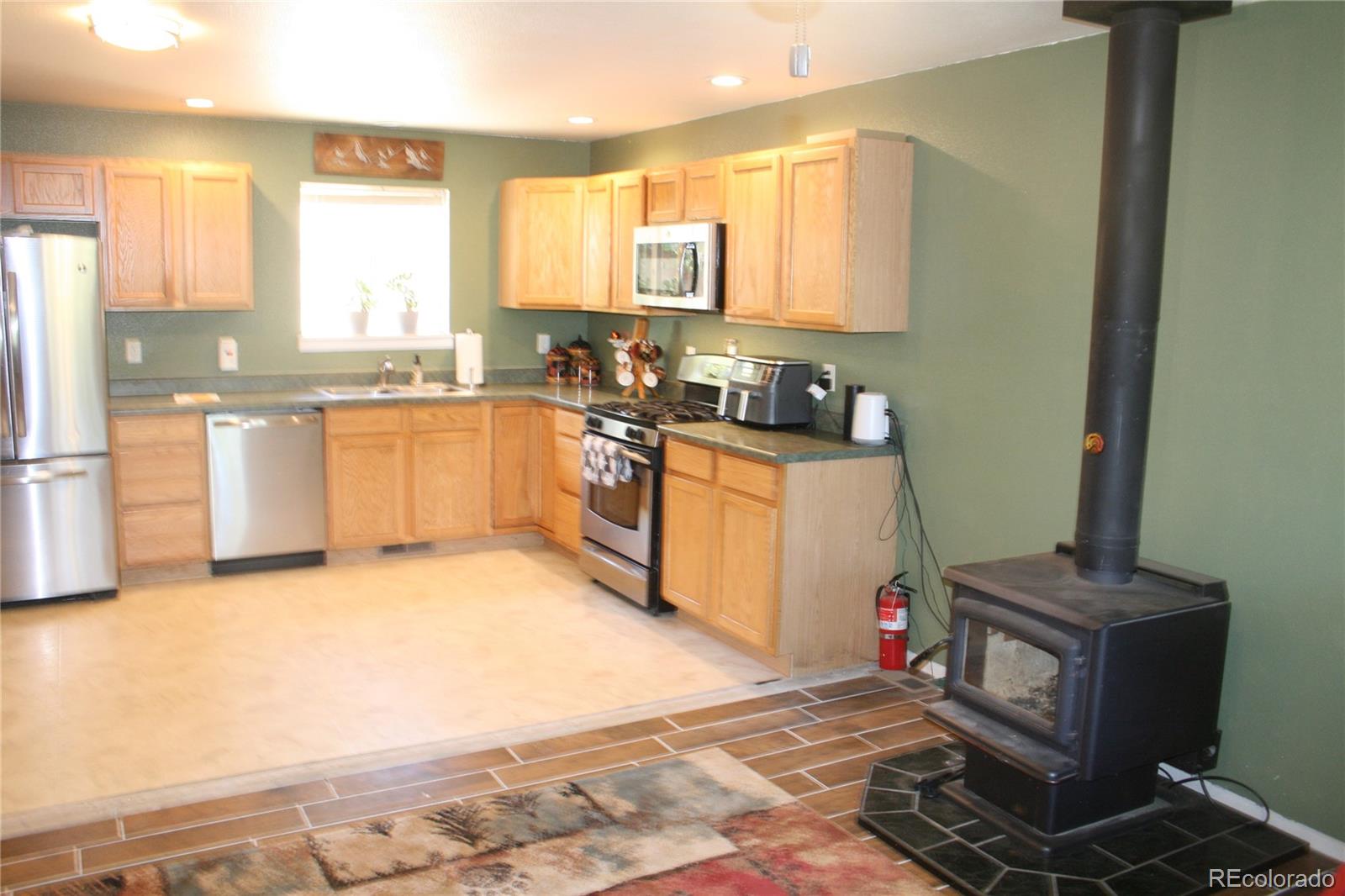 238 Taylor Street Bailey, CO 80421 - Photo 14 of 23 a kitchen with granite countertop a sink cabinets stainless steel appliances and a window