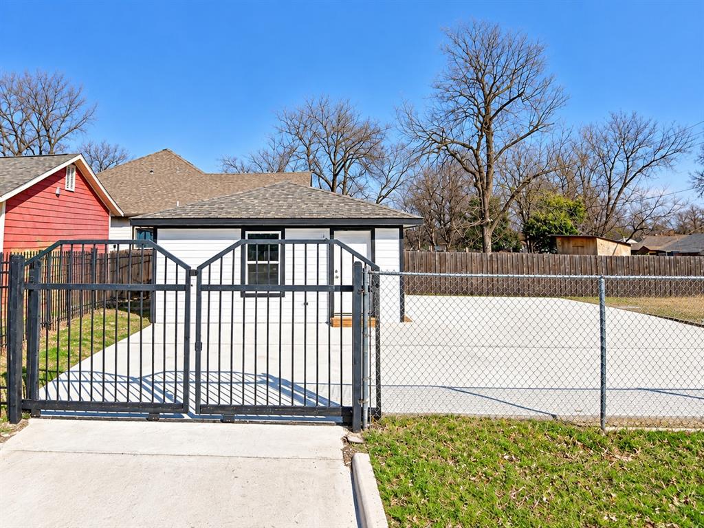 2102 East Overton Road, Unit B Dallas, TX 75216 - Photo 1 of 8 Private gated entry with concrete driveway and chain-link fencing