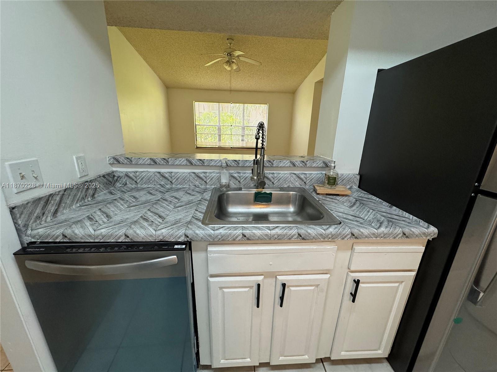 4341 West McNab Road, Unit 27 Pompano Beach, FL 33069 - Photo 13 of 50 a kitchen with a granite countertop sink stove and cabinets