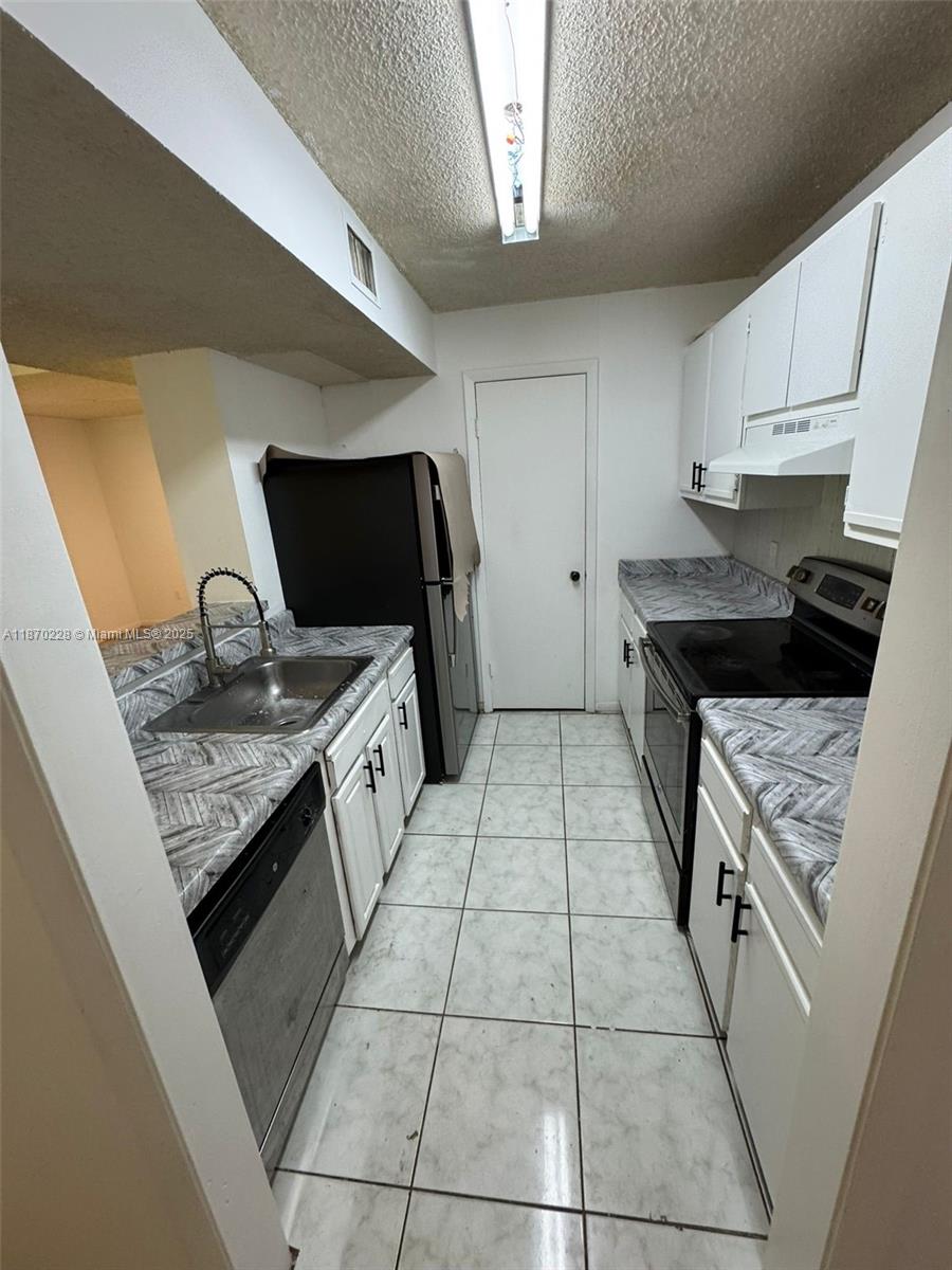 4341 West McNab Road, Unit 27 Pompano Beach, FL 33069 - Photo 14 of 50 a kitchen with a stove a sink and a refrigerator