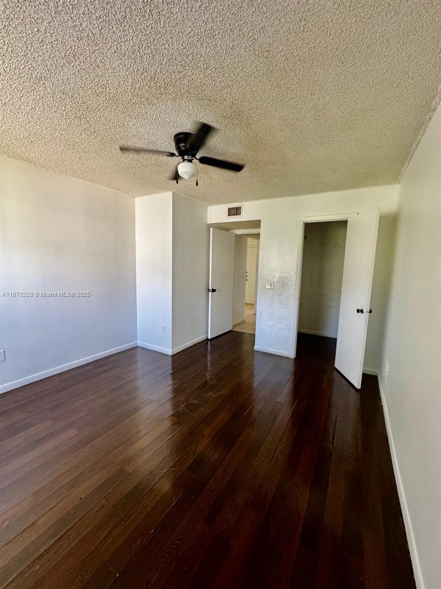 4341 West McNab Road, Unit 27 Pompano Beach, FL 33069 - Photo 19 of 50 a view of empty room with wooden floor and ceiling fan