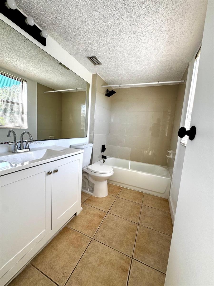 4341 West McNab Road, Unit 27 Pompano Beach, FL 33069 - Photo 30 of 50 a bathroom with a double vanity sink a toilet and a mirror