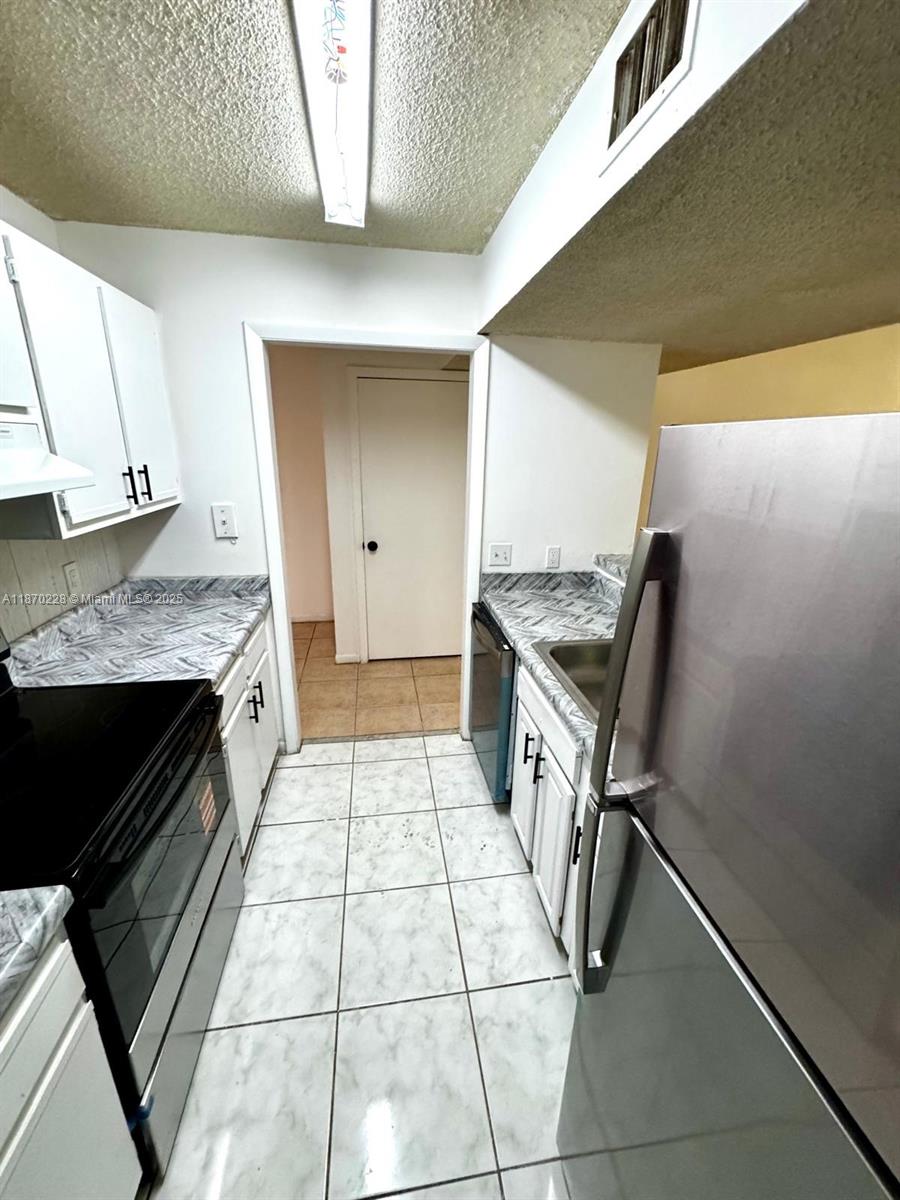 4341 West McNab Road, Unit 27 Pompano Beach, FL 33069 - Photo 37 of 50 a kitchen with granite countertop a sink stove and cabinets
