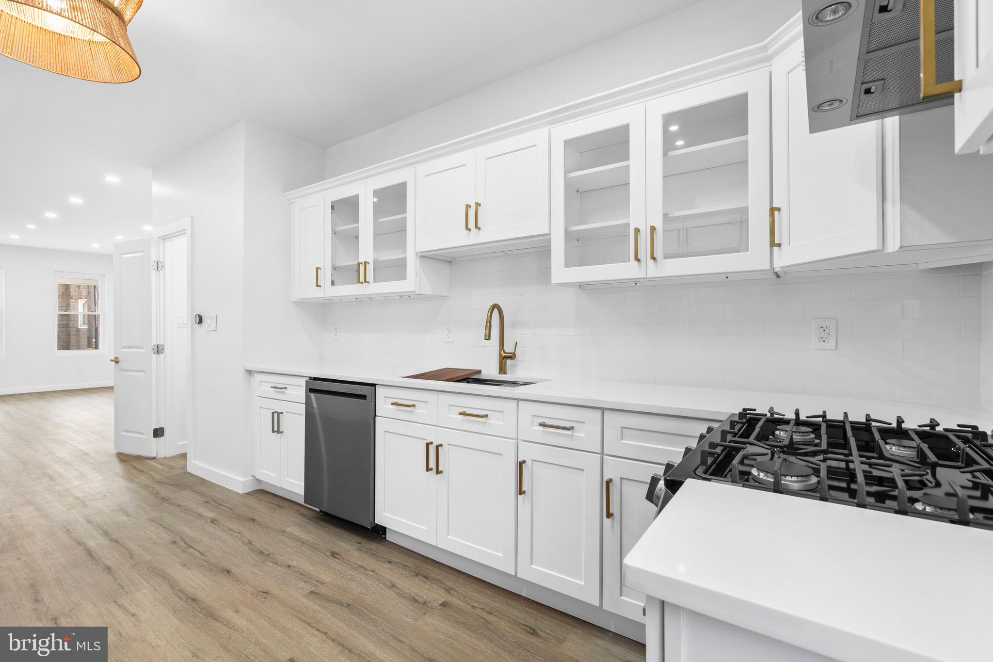 5541 Race Street Philadelphia, PA 19139 - Photo 12 of 37 a kitchen with stainless steel appliances a sink a stove and white cabinets