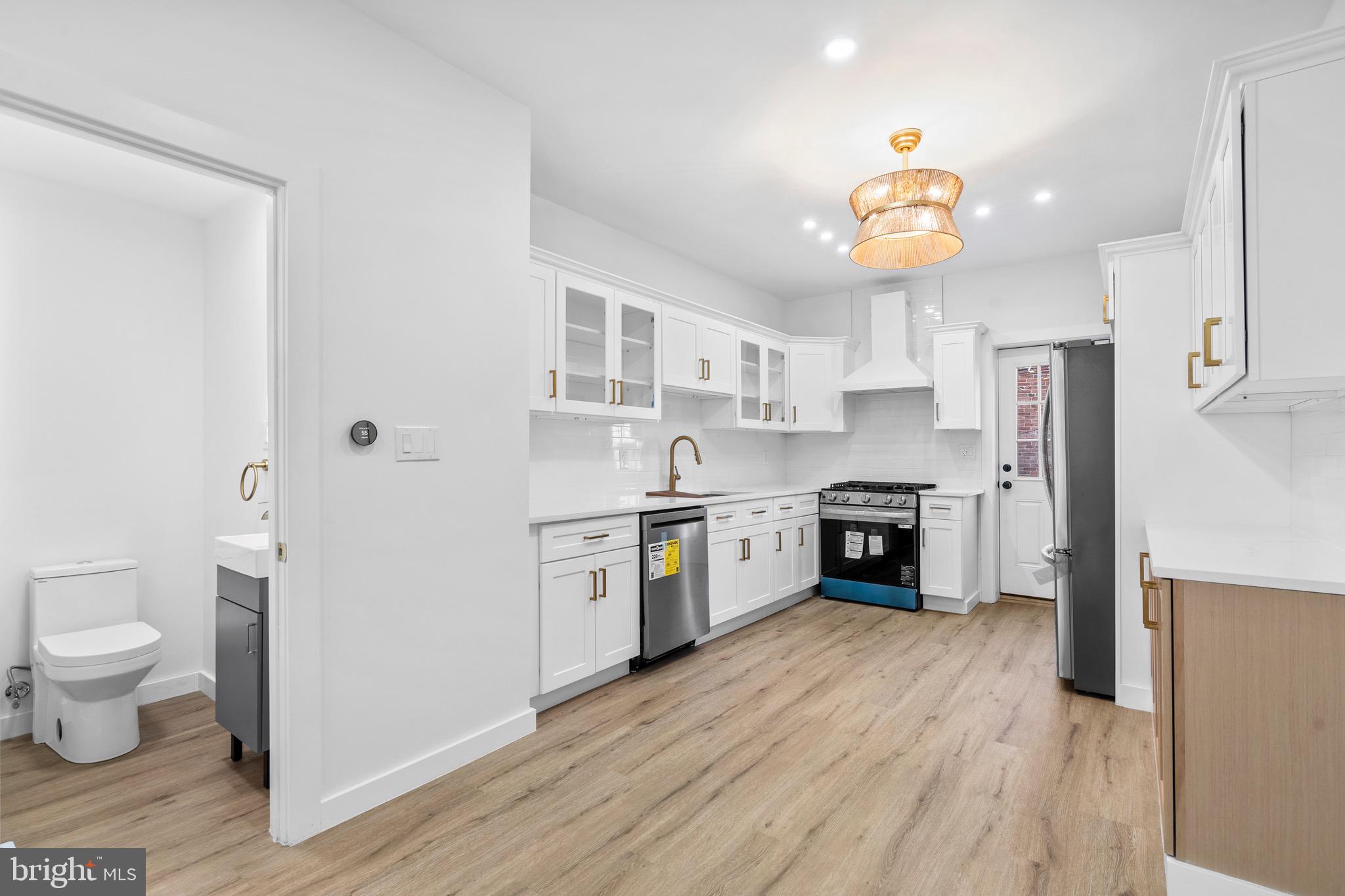 5541 Race Street Philadelphia, PA 19139 - Photo 6 of 37 a large kitchen with stainless steel appliances a stove a refrigerator and a sink