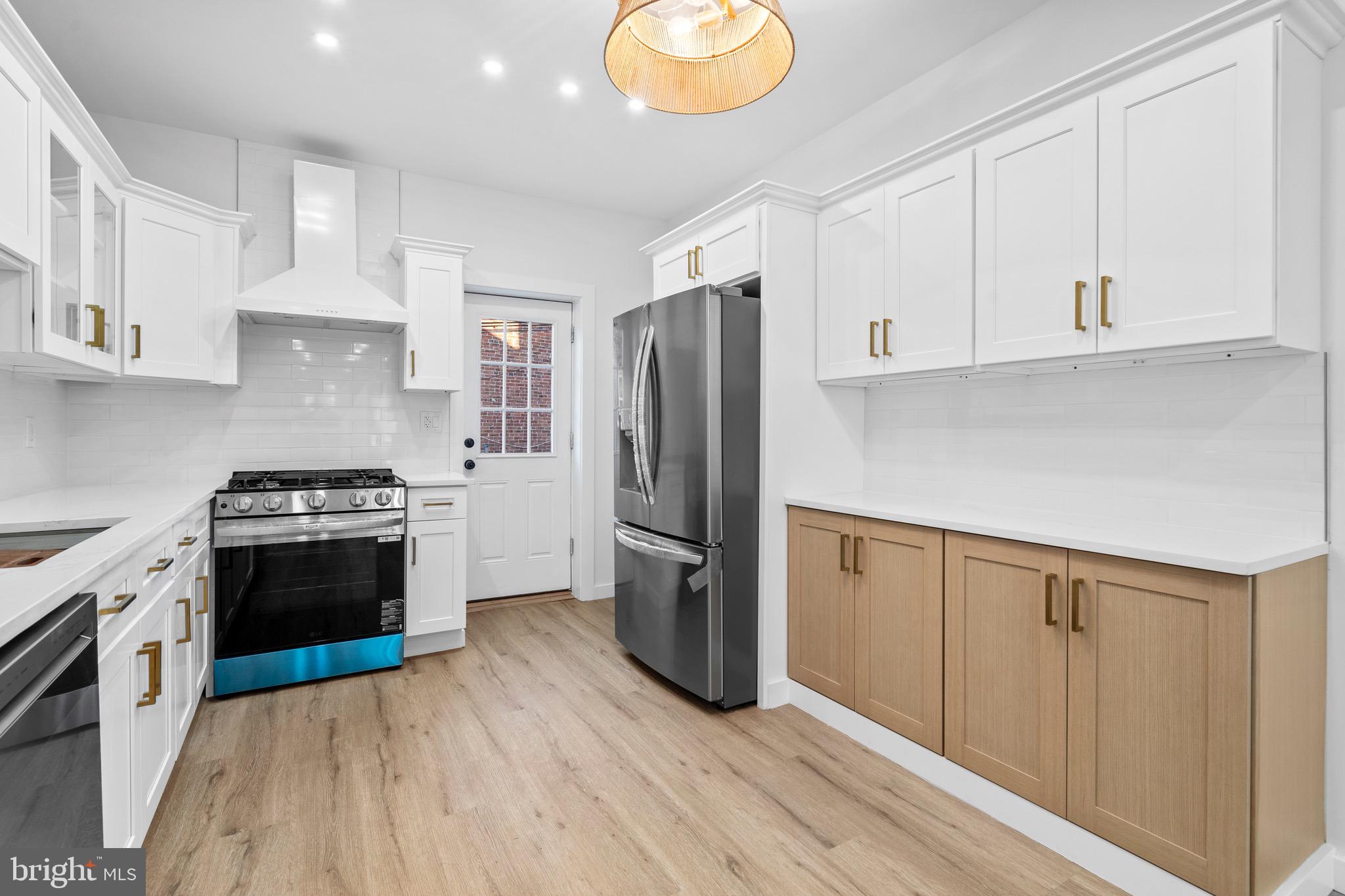 5541 Race Street Philadelphia, PA 19139 - Photo 9 of 37 a kitchen with a refrigerator stove and white cabinets