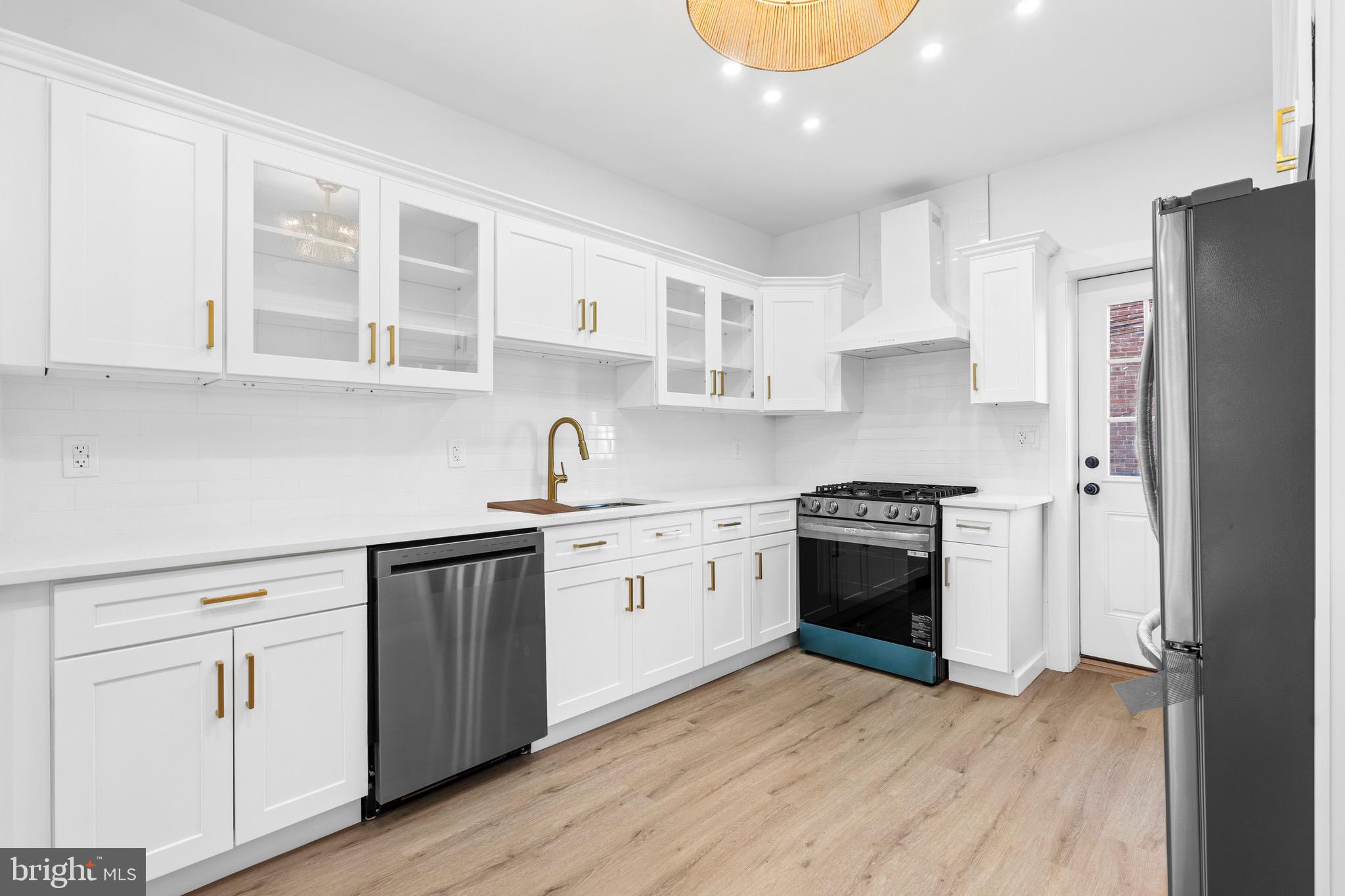 5541 Race Street Philadelphia, PA 19139 - Photo 10 of 37 a kitchen with stainless steel appliances granite countertop a stove and white cabinets