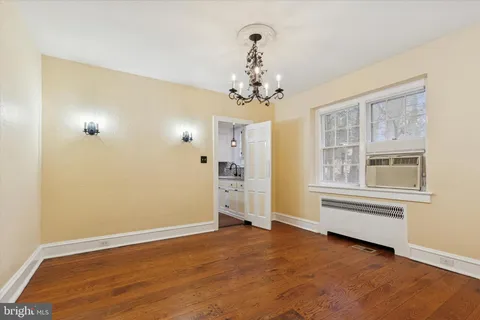 an empty room with a windows and chandelier fan
