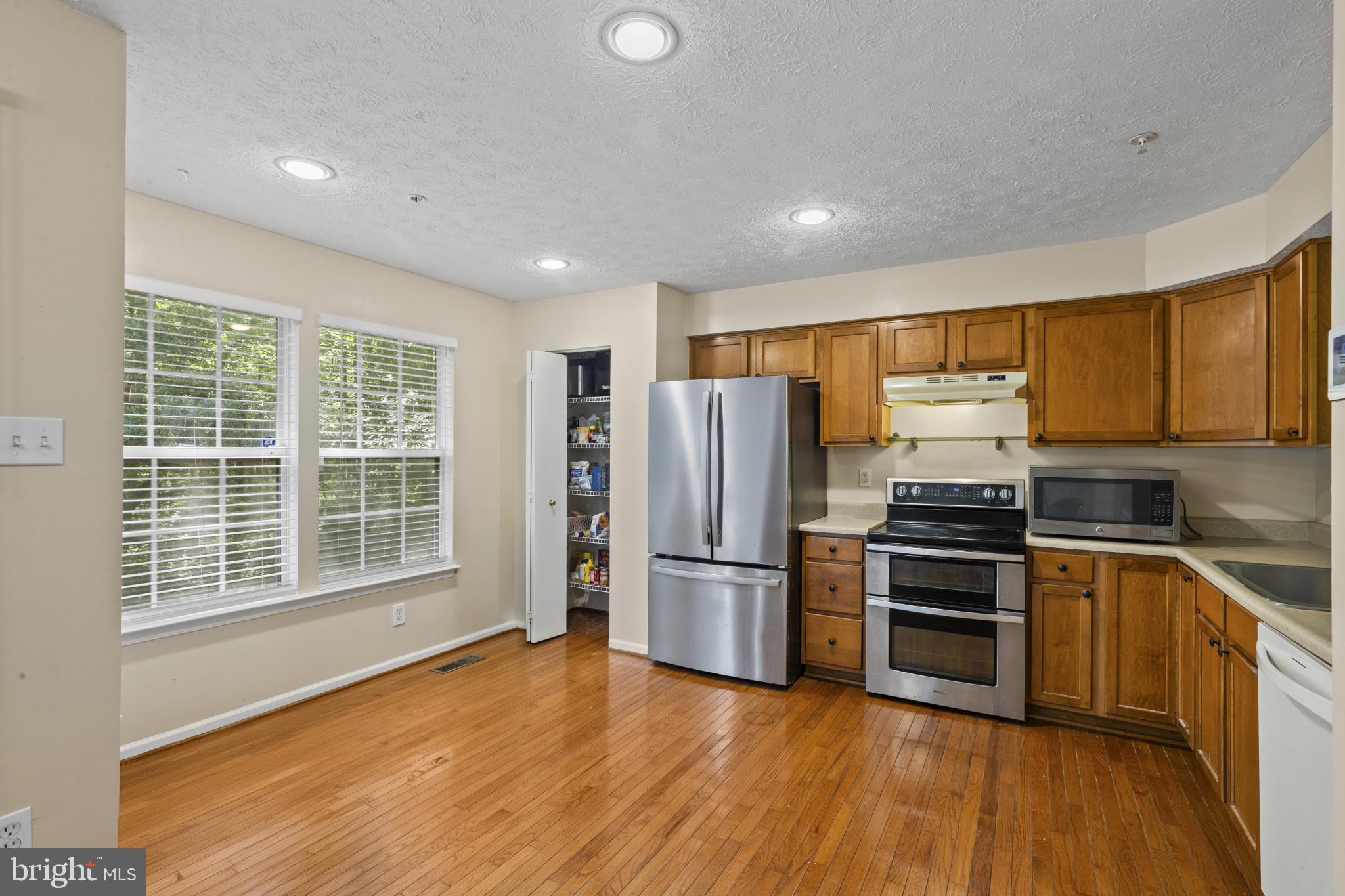 2042 Hackberry Road Baltimore, MD 21221 - Photo 11 of 26 a kitchen with stainless steel appliances a refrigerator and wooden floor