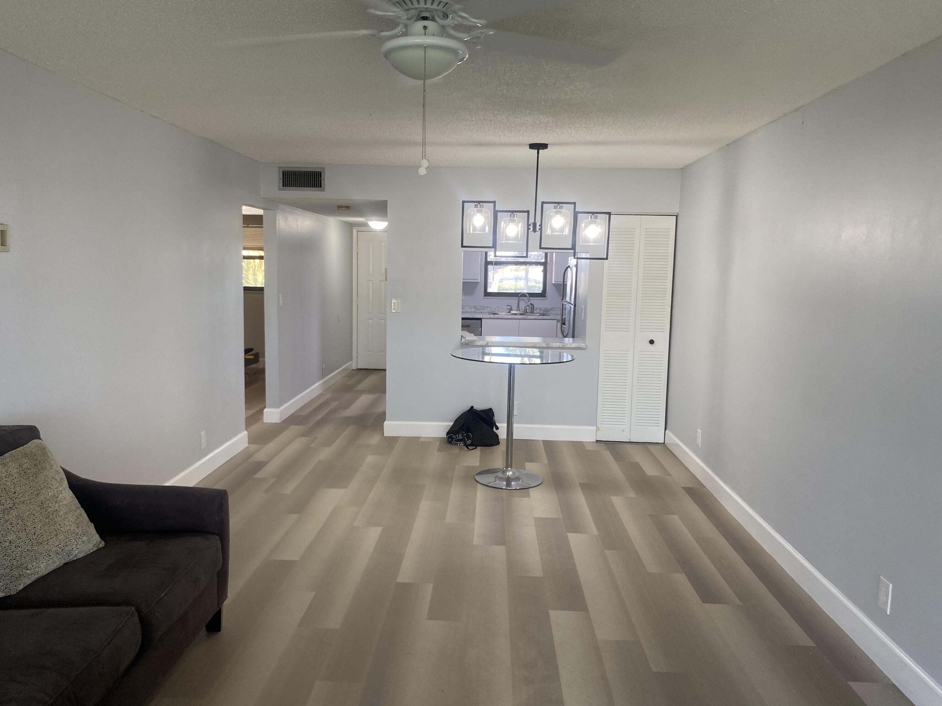2181 Woolbright Road, Unit N201 Boynton Beach, FL 33426 - Photo 3 of 15 a view of a livingroom with a furniture wooden floor and chandelier