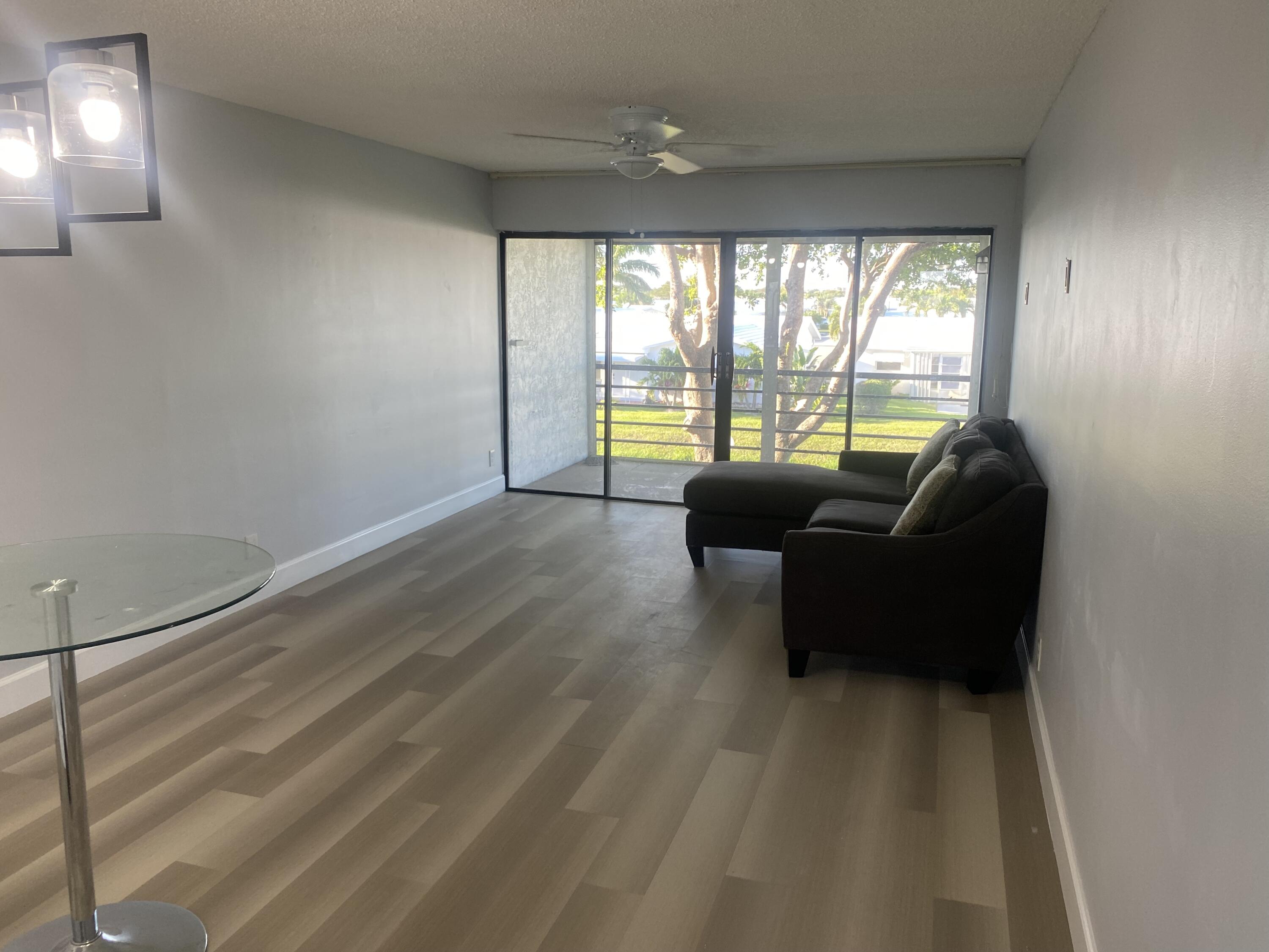 2181 Woolbright Road, Unit N201 Boynton Beach, FL 33426 - Photo 4 of 15 a living room with furniture and a large window