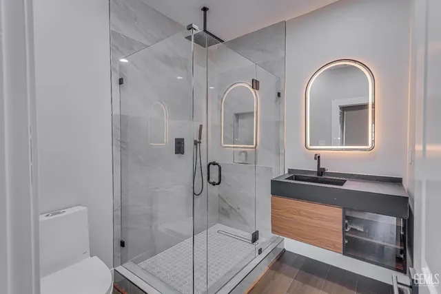 a bathroom with a double vanity sink toilet and shower