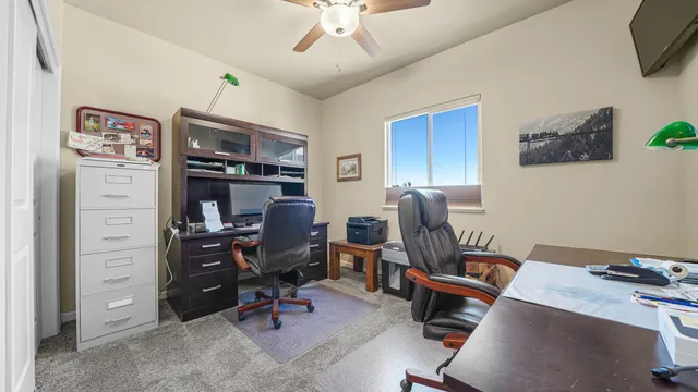 a view of a workspace with furniture and a window