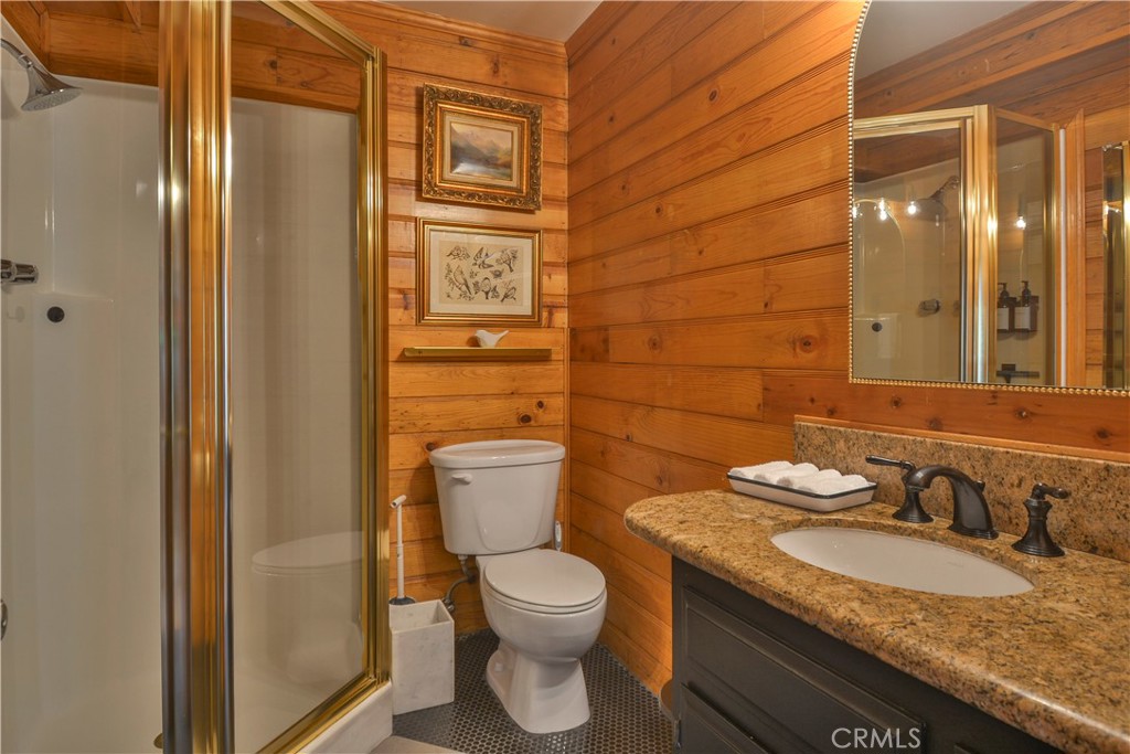761 Arrowhead Villa Road Lake Arrowhead, CA 92352 - Photo 16 of 31 a bathroom with a granite countertop toilet a sink and a mirror