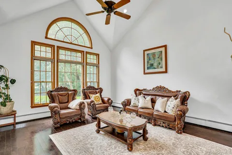 a living room with furniture and a large window with wooden floor