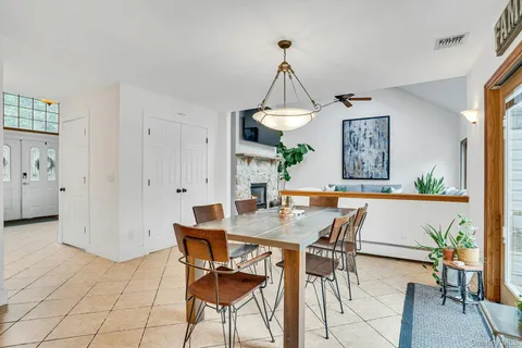 a kitchen with stainless steel appliances granite countertop a refrigerator a sink a stove a dining table and chairs