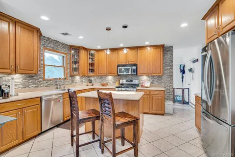 a kitchen with a sink stove and chairs