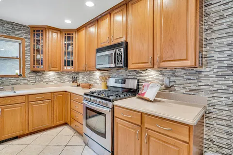 a kitchen with a refrigerator a stove a sink and a dining table with wooden floor