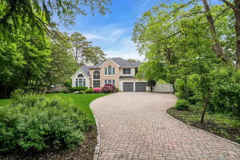 a front view of a house with a yard and trees