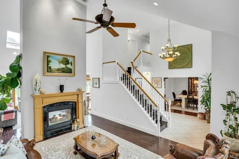 a living room with furniture a rug a wooden floor and a large window