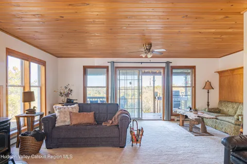 a living room with furniture and floor to ceiling windows