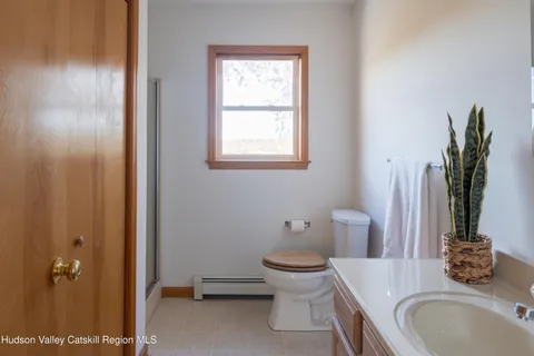 a bathroom with a granite countertop toilet a sink and a mirror