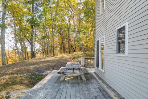 a view of a patio with chairs and table on the wooden floor