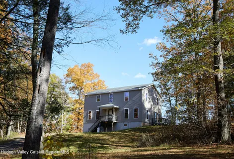 a front view of a house with a tree