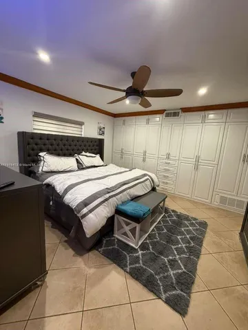 a bedroom with two beds and a ceiling fan