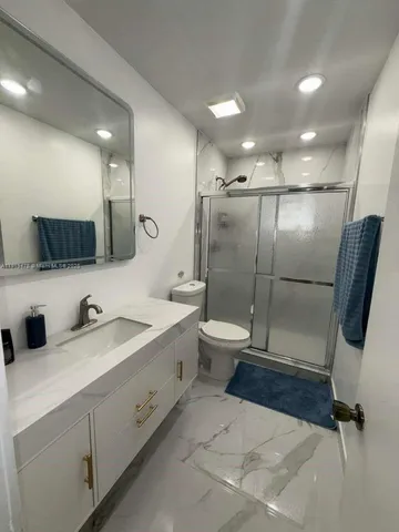 a bathroom with a sink toilet and shower