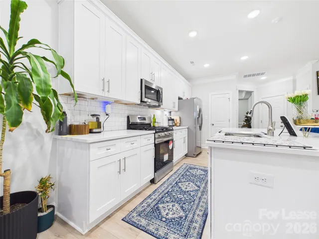 a kitchen with stainless steel appliances granite countertop a sink a stove and cabinets