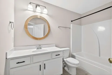 a bathroom with a sink a toilet and a mirror