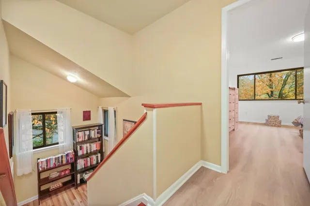 a view of a hallway with wooden floor and staircase