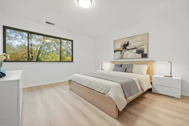 a bedroom with a bed and a large window