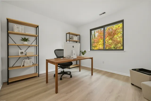 a workspace with wooden floor and a window