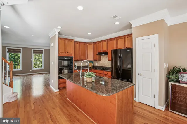 a kitchen with stainless steel appliances granite countertop a refrigerator and a stove top oven