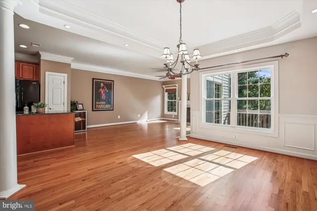 a view of an empty room with wooden floor fireplace and a window